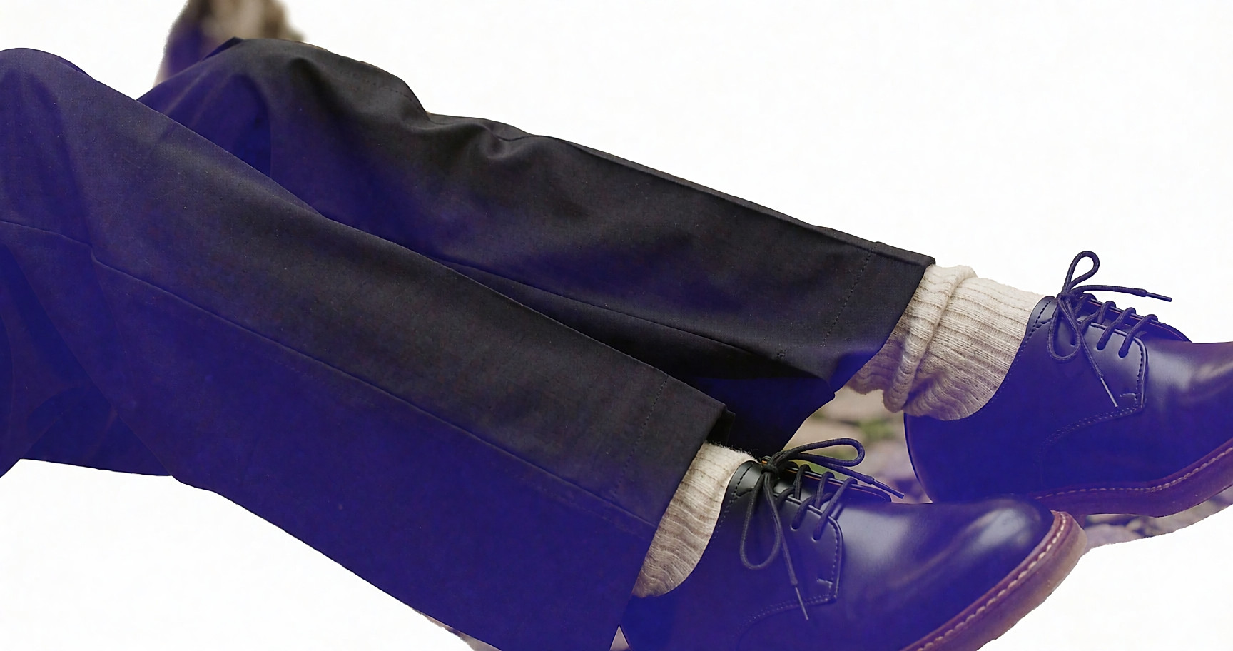 Chaussettes hautes en laine sous un pantalon large, portées avec des derbies