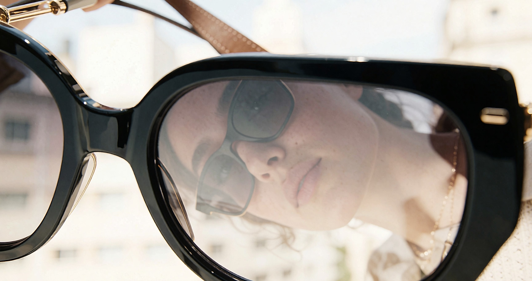 Jeune femme portant des lunettes oversize et un grand cabas en cuir à l'épaule