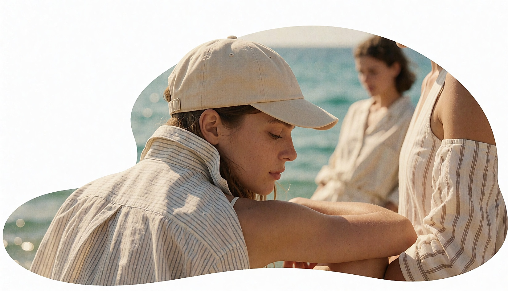 Jeune femme de trois-quarts dos portant une casquette en coton beige au bord de la mer