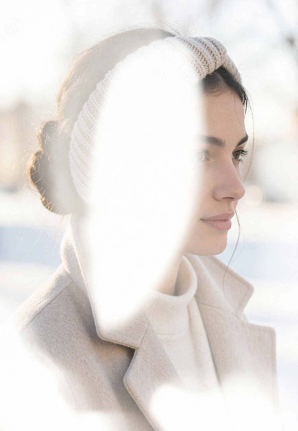 Vue de trois-quarts arrière d'une jeune femme portant un bandeau de maille sur un chignon bas