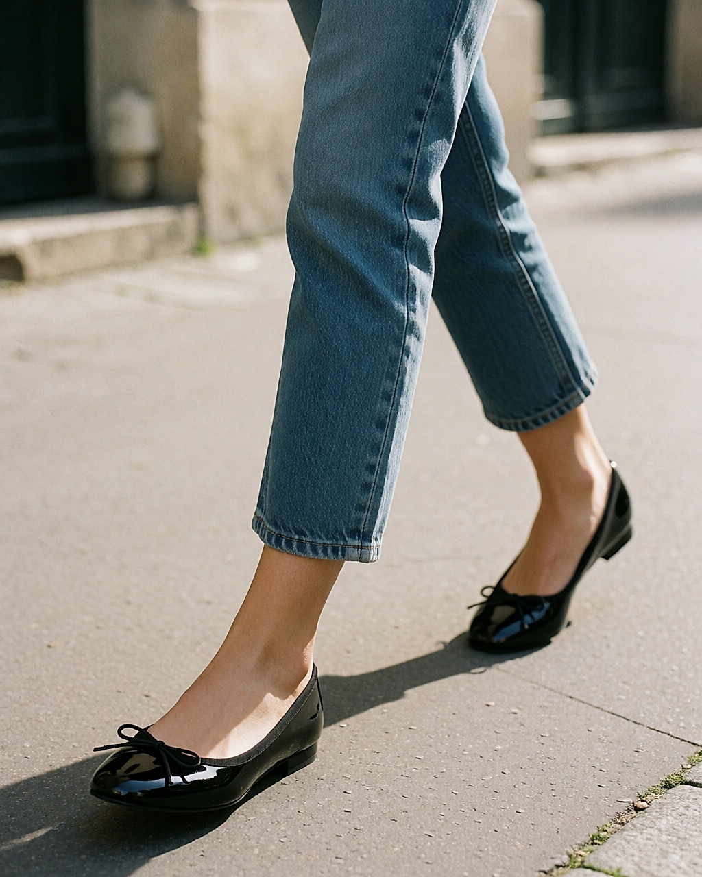 Ballerines noires vernies à petit nœud portées dans la rue