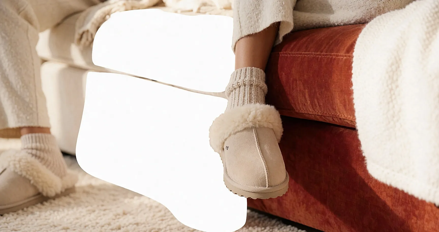 Feet in shearling-lined slippers on a thick rug