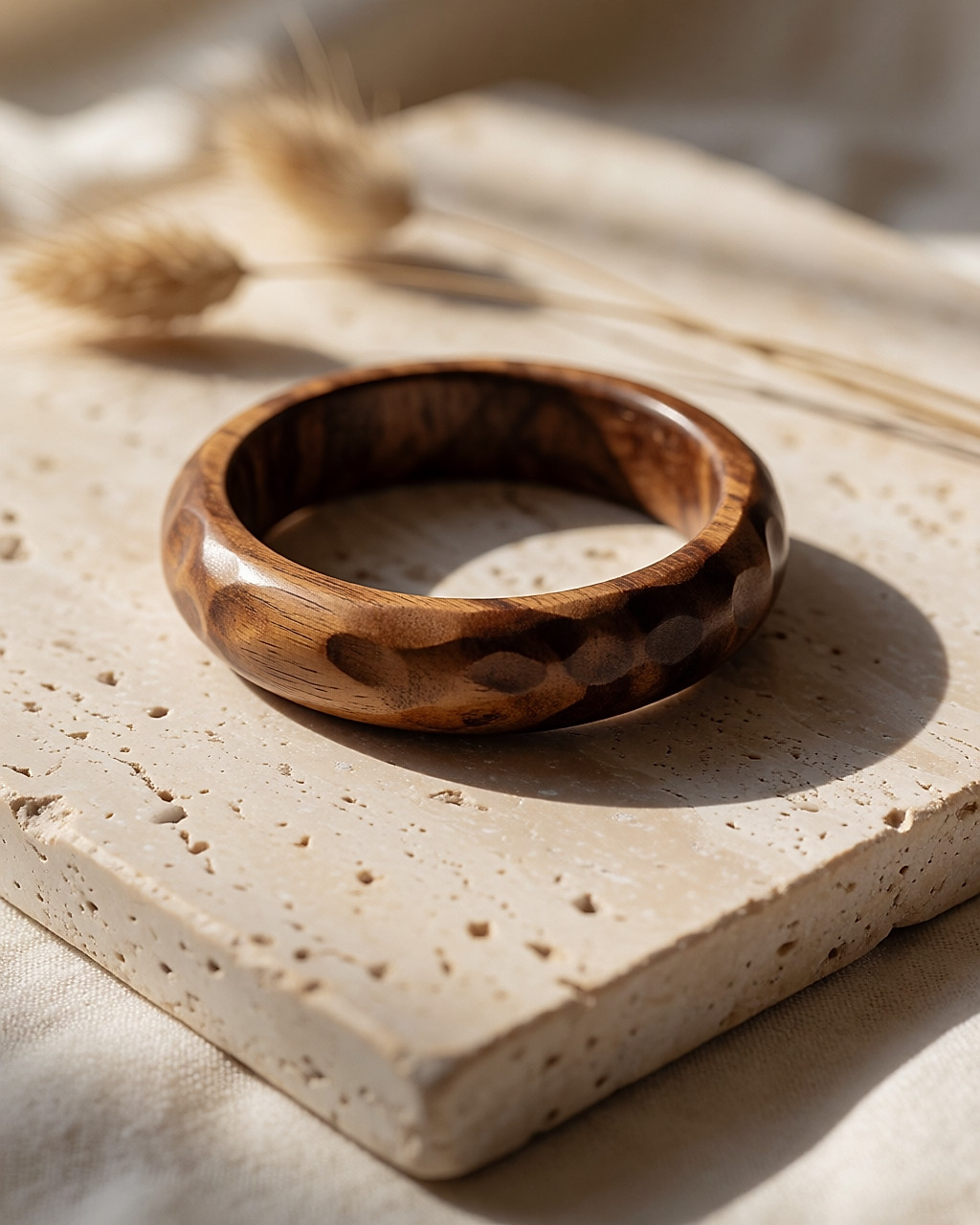 Carved wooden bangle placed on light stone