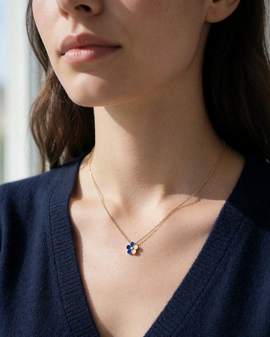 Collier fin doré à pendentif fleur émaillée bleu et rose porté sur une maille marine