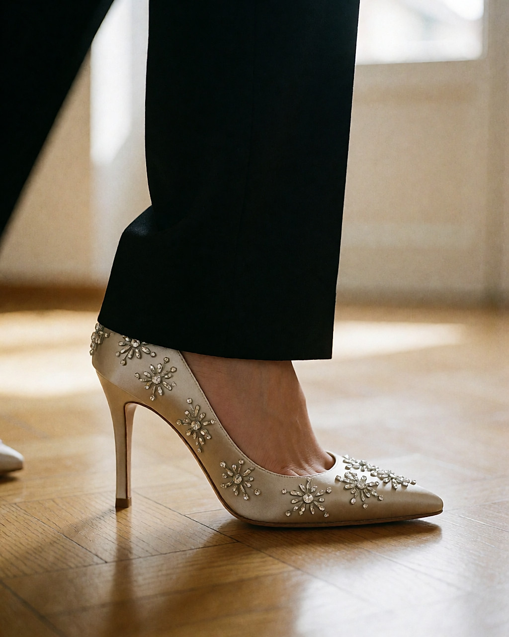 Escarpin de satin entièrement strassé, porté sur un parquet clair