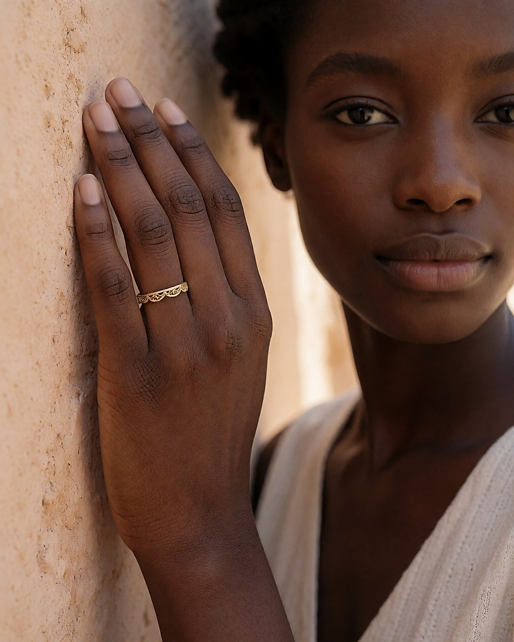 Bague fine en or jaune au travail de filigrane, portée sur une main, gros plan rapproché