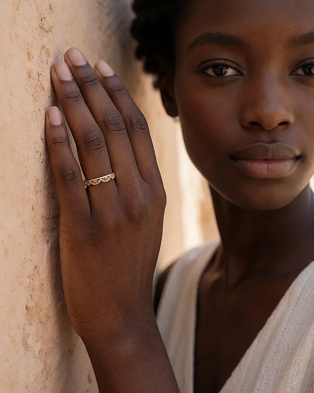 Anillo fino de oro amarillo con trabajo de filigrana, llevado en una mano, primer plano