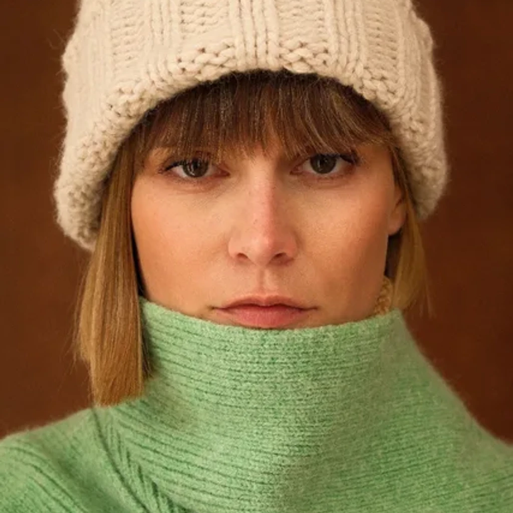Bonnet en grosse maille torsadée porté bas, dans une rue d'hiver