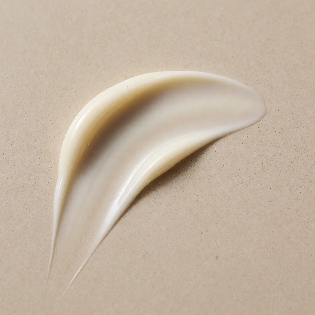 Une texture de gel-crème légère étalée en arc sur une surface beige