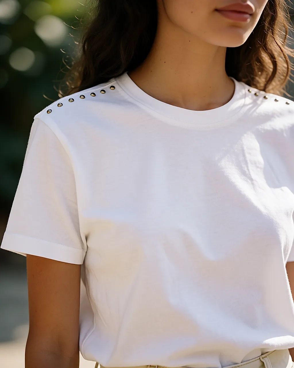 A white cotton T-shirt with small studs lined up on the shoulder