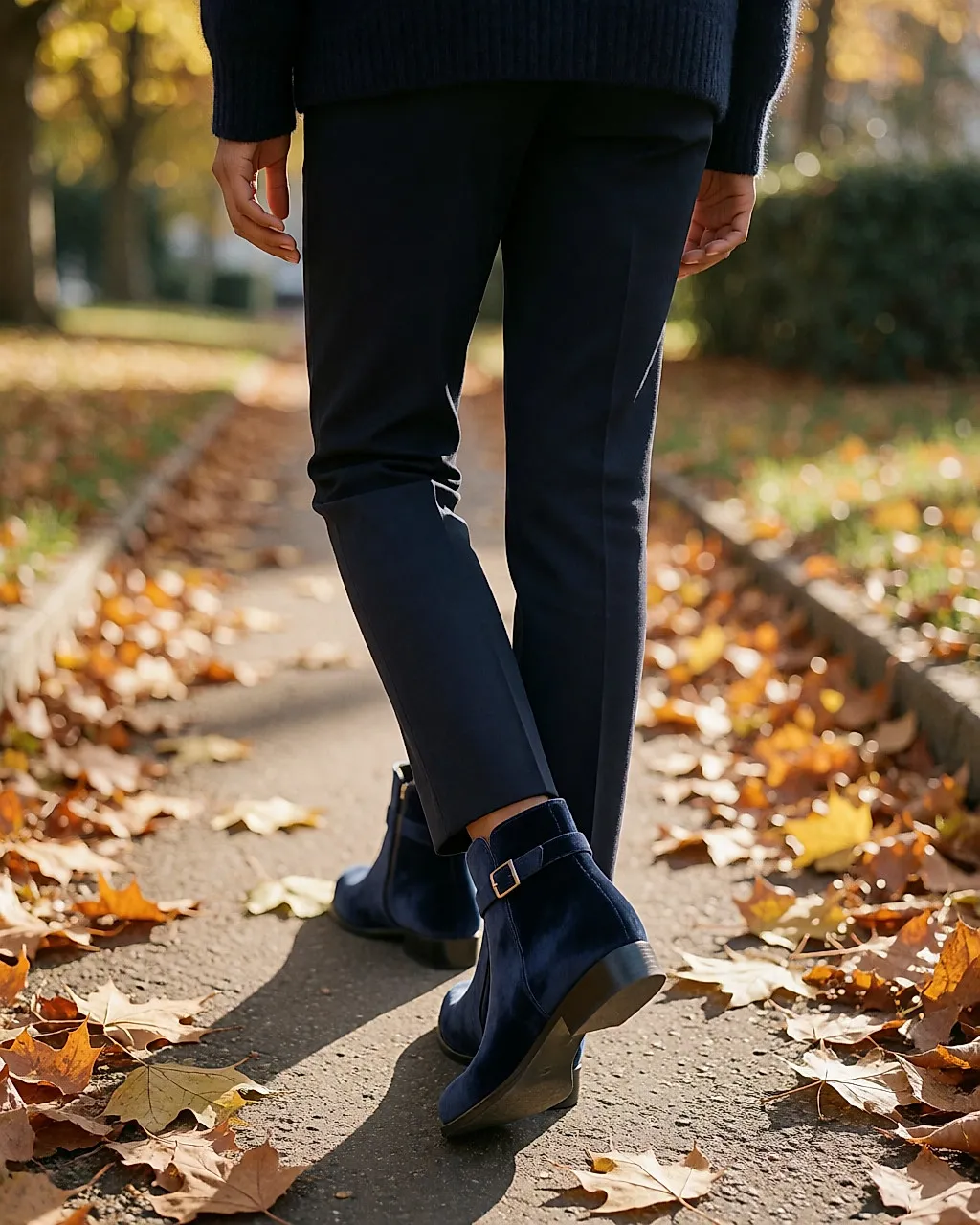 Frau von hinten beim Gehen, marineblaue Veloursleder-Boots mit Riemen