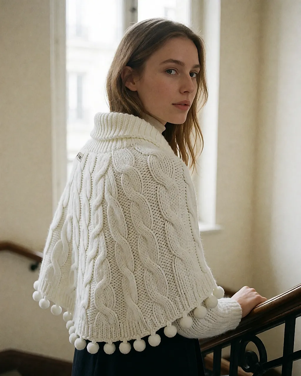IKKS white cape-cardigan with cables and pom-poms, roll neck, worn over a fine knit
