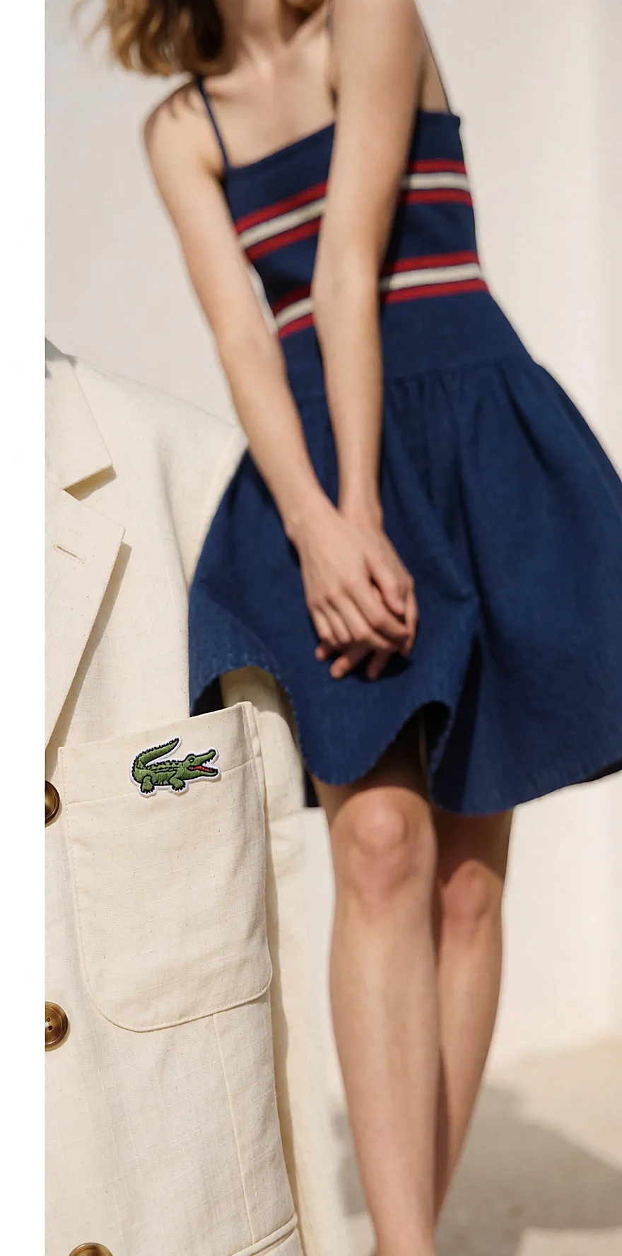 Close-up of the green crocodile embroidered in silk thread on the pocket of a cream jacket