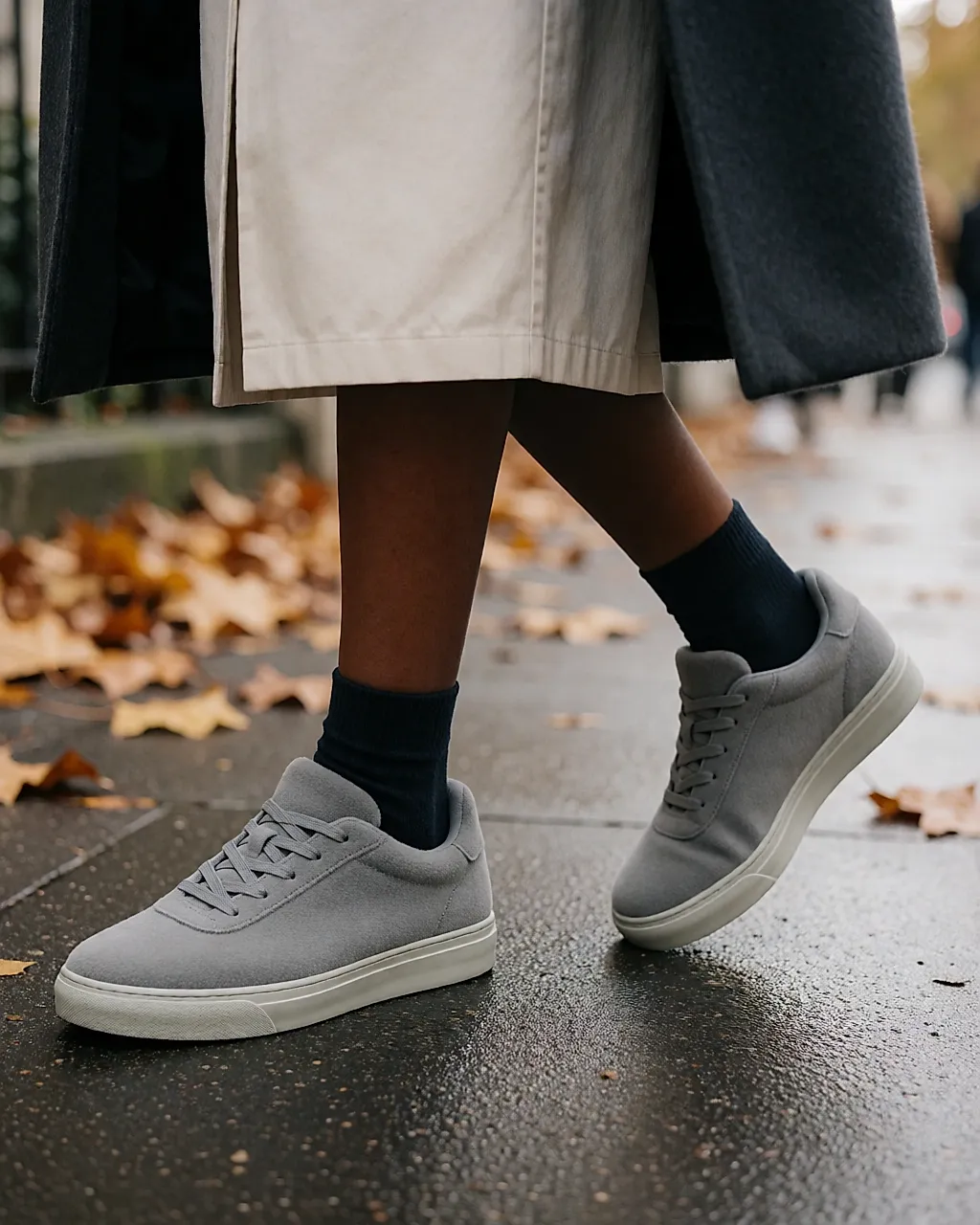 Zapatillas de felpa gris jaspeada sobre una acera urbana, paso en movimiento