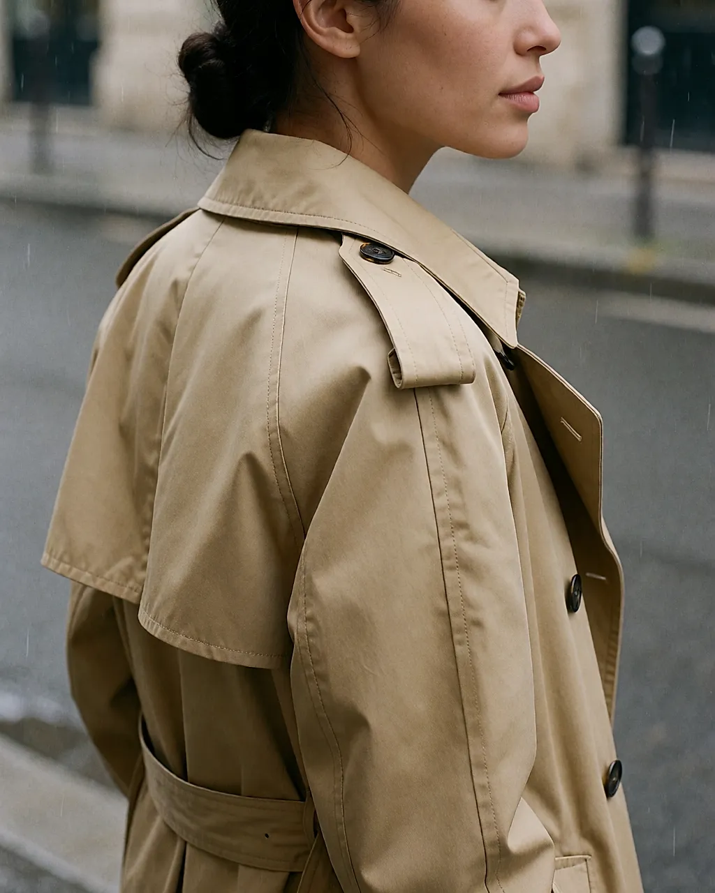 Ein klassischer beiger Trenchcoat im Regen, Tropfen perlen auf dem Gabardine ab