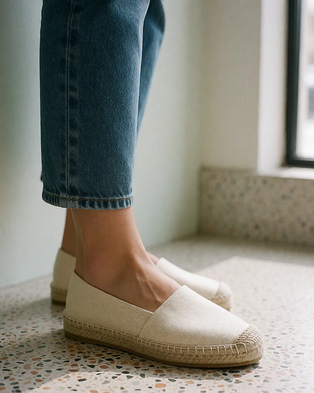 Detail eines Fußes in einer flachen Espadrille mit handgenähter Juttesohle