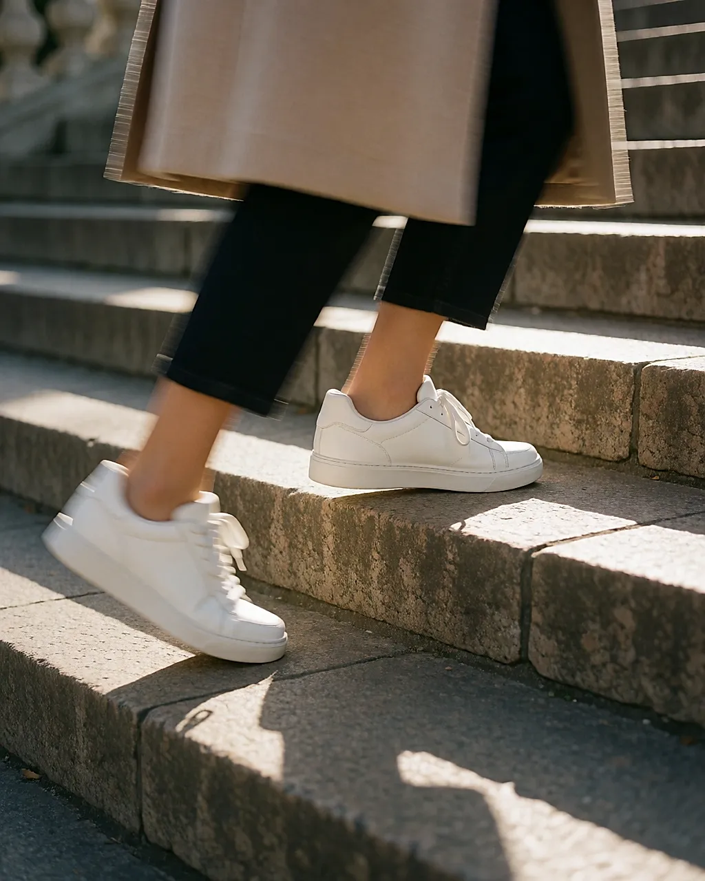 Pieds en baskets montant un escalier de pierre en extérieur, en pleine foulée