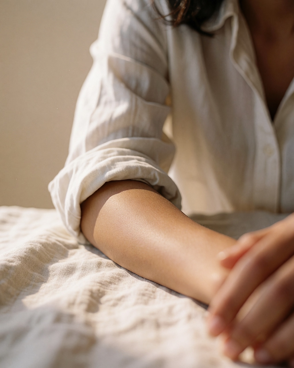 Skin on a forearm covered in fine droplets of sweat, close-up in warm light