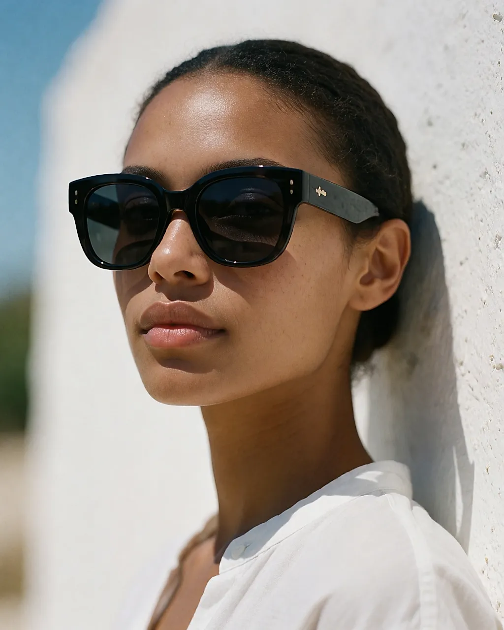Close-up of a woman in bright sunshine, very dark lenses covering the eye contour