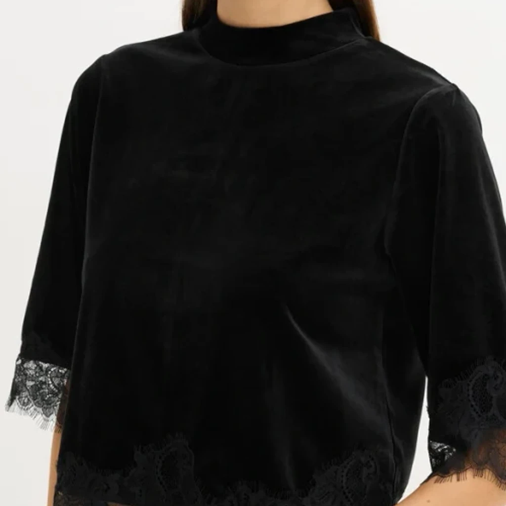 Romantic blouse with embroidered lace sleeves worn by a model