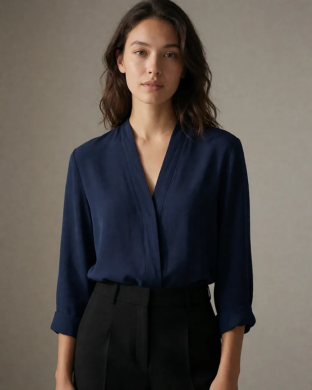 Young woman in a navy blouse and black trousers, contrasting textures