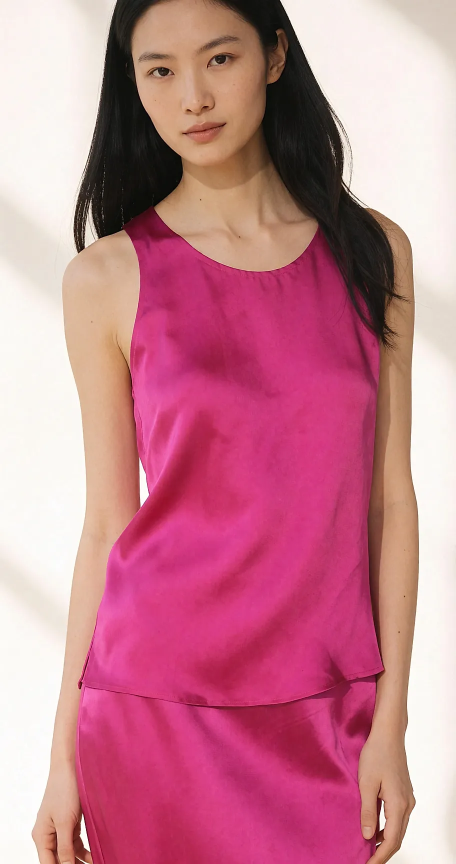 Halbporträt einer jungen Frau in einer Fuchsia-Seidenbluse, weiches Tageslicht