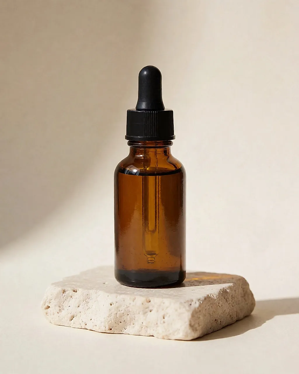 Hyaluronserum in einem Pipettenfläschchen auf hellem Stein.