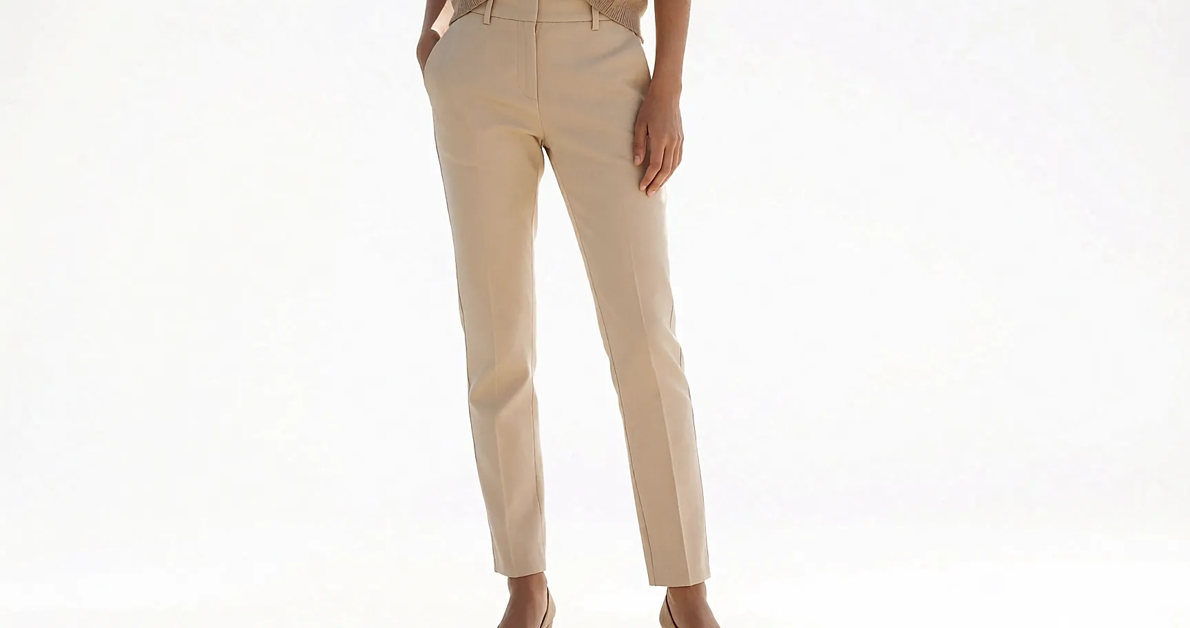 Nude slim-fit trousers worn, clean drape, hem sitting above the ankle