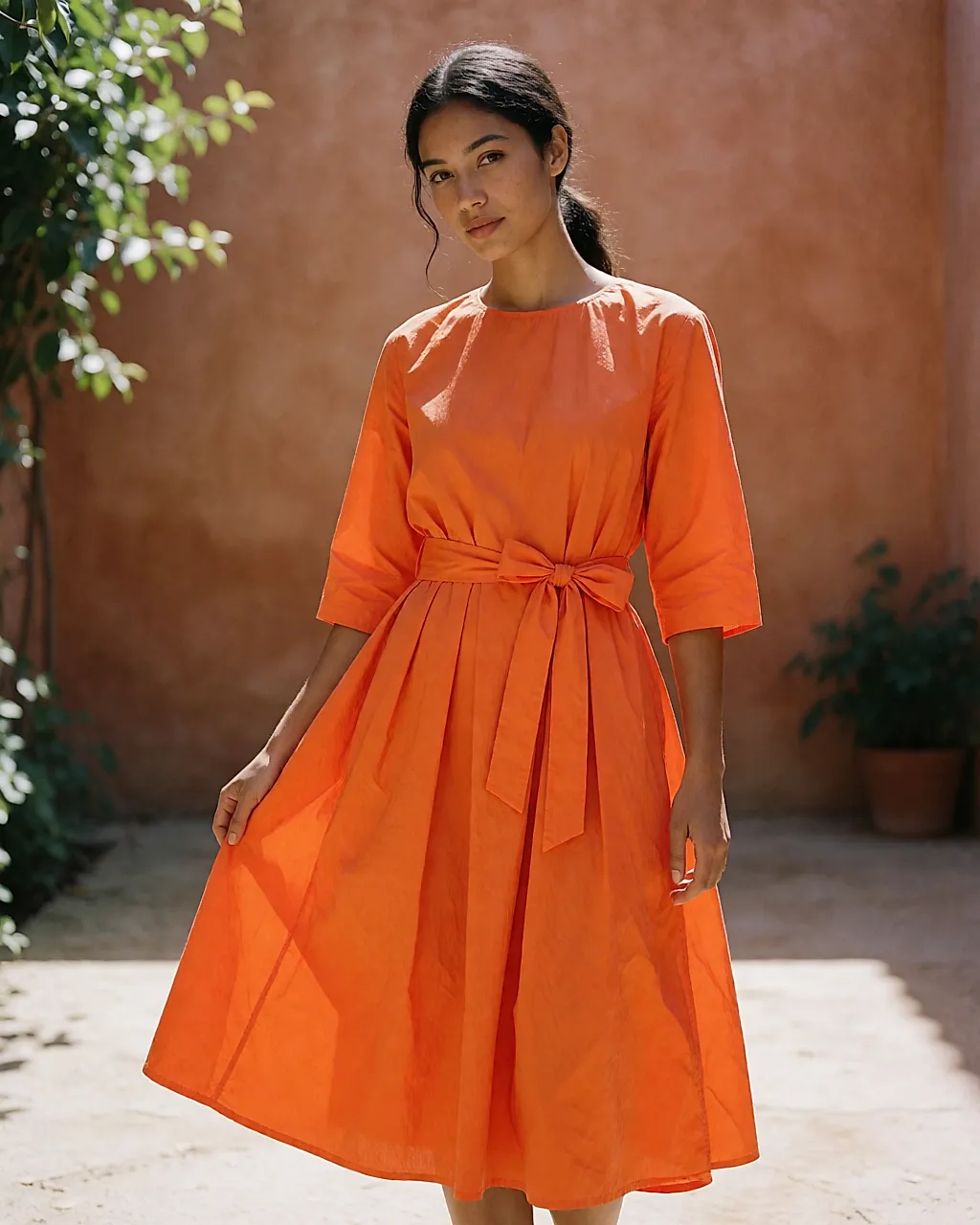 Vestido midi naranja flúor de algodón popelín puesto en un patio