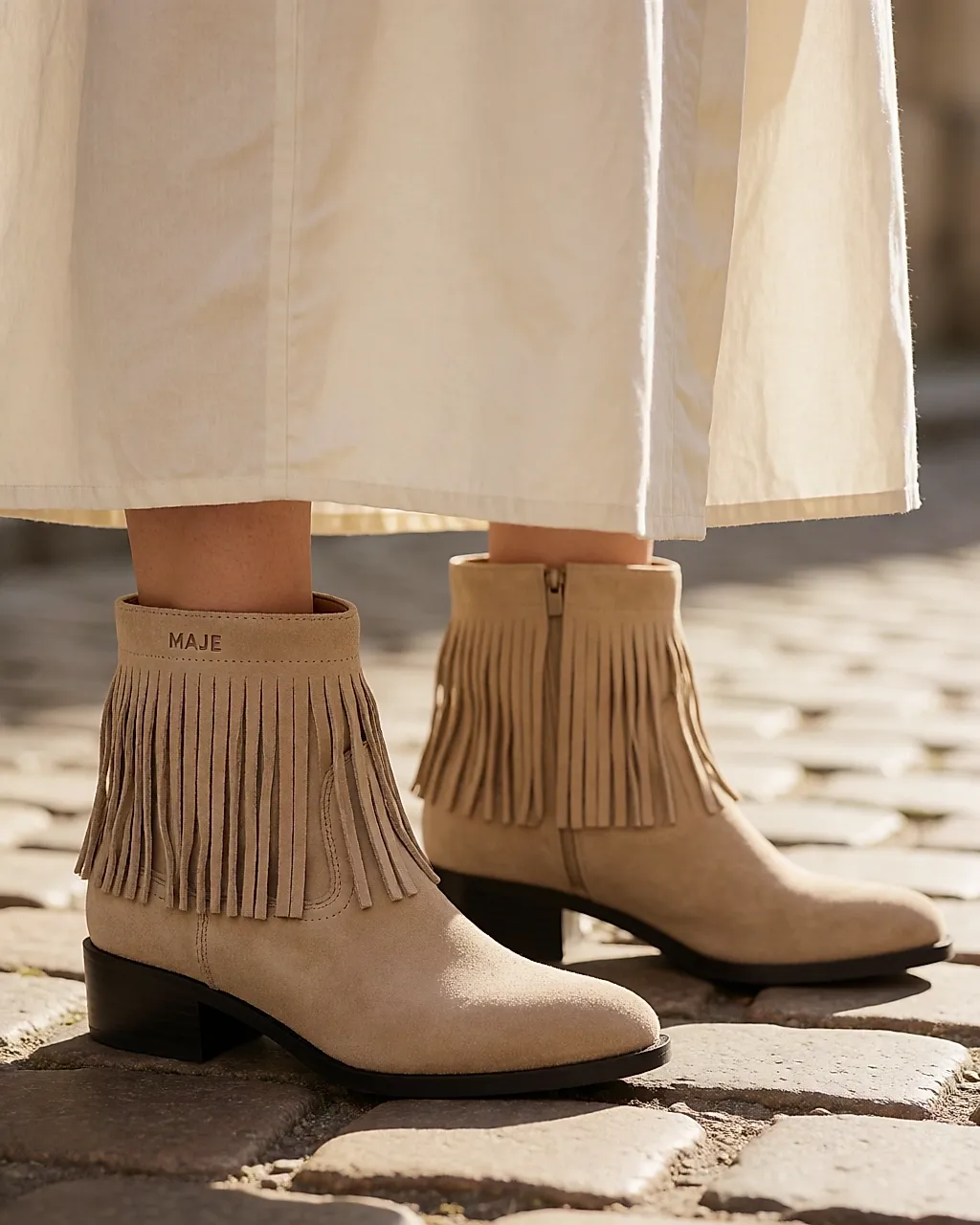 Beige suede fringed ankle boots worn with a long skirt