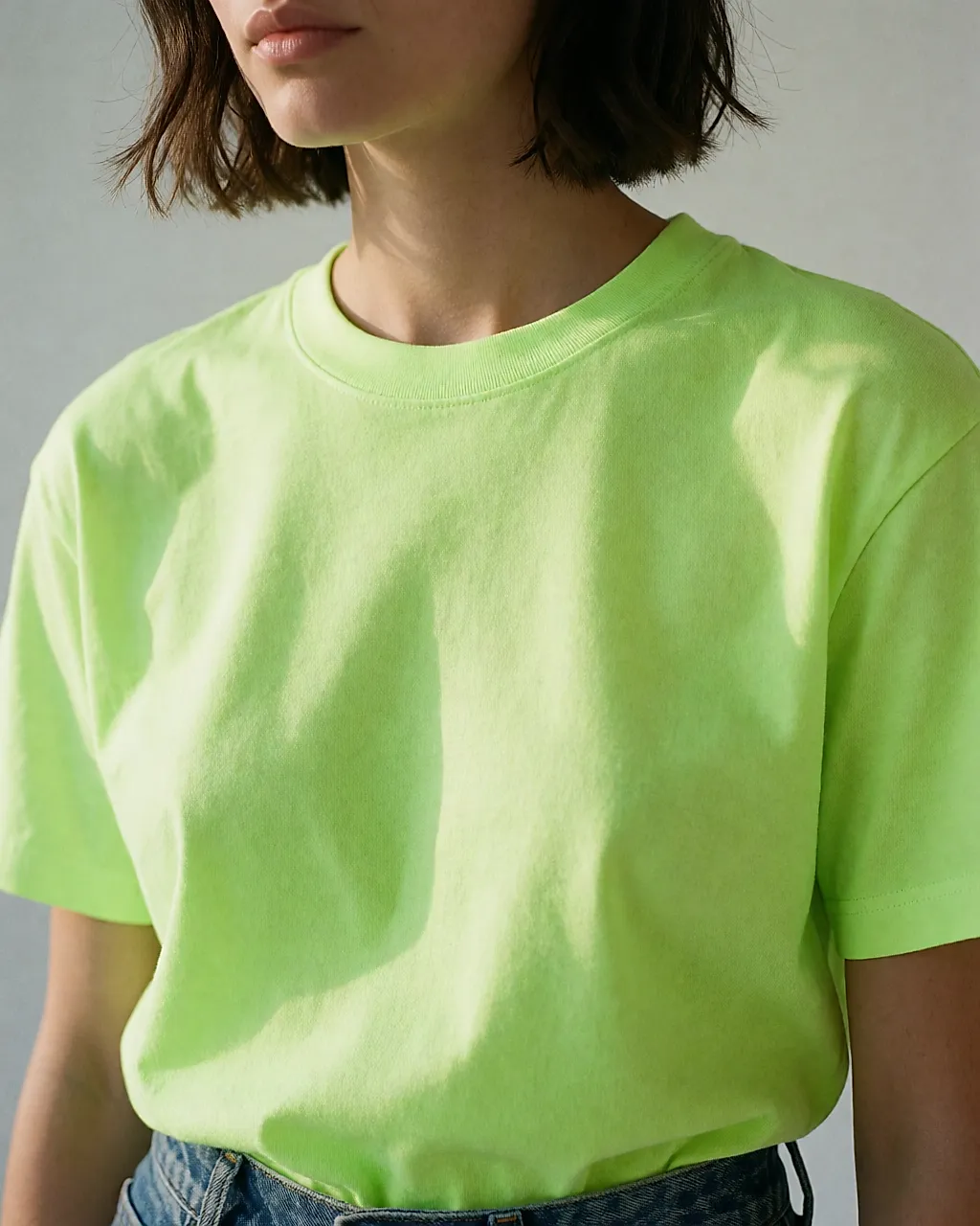 Detalhe de uma T-shirt verde néon com ganga crua