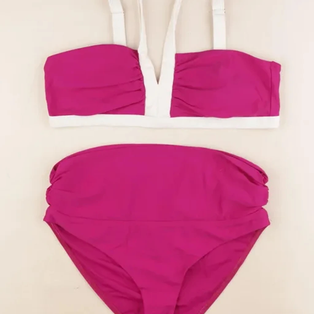 Fotografia de produto inspirada em fato de banho inteiro com debrum rosa sobre fundo preto